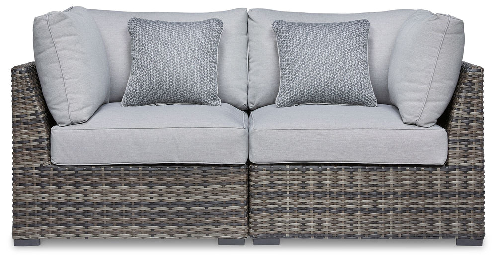 This cool, casual outdoor chair will raise the comfort level and visual appeal of your outdoor living space. Made of handwoven wicker in neutral tones of light and dark gray, the cushioned corner chair blends beautifully into your lanai or pool and patio 