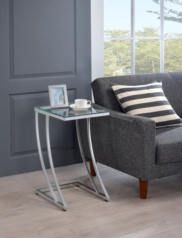 featuring a clear tempered glass top that blends sleek modernity with durability. The gracefully curved metal frame in an electroplated chrome finish adds sophistication and strength