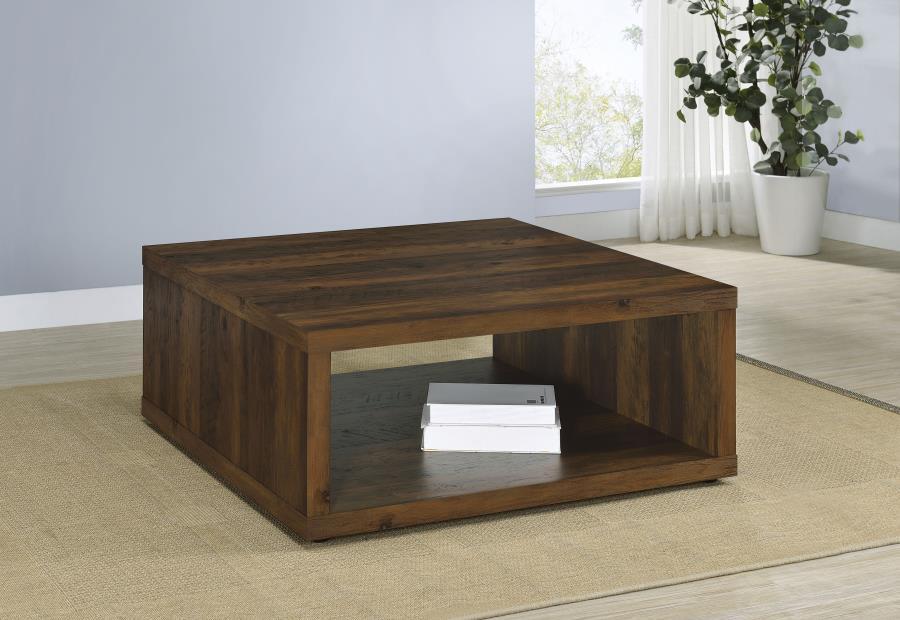 This coffee table combines rustic charm and modern simplicity, crafted from durable engineered wood with a dark pine wood-look finish. Its cube-inspired design features two open sides and a lower shelf for practical storage or display. The wood look lamin