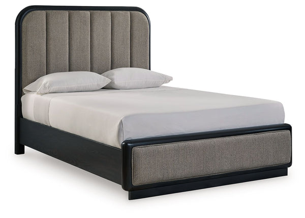 Inspired by art deco design, this softly shaped queen upholstered panel bed makes a lasting impression in a simply stunning way. Its magnificent curved silhouette is enhanced by a rich layered black finish on the textured wood grain surface. The channeled