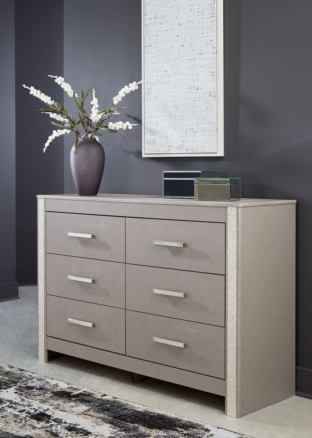 Love sleek and bold contemporary style? Drink in the beauty of this dresser. Its eye-catching details include glam glitter accents and the look of leather grain with a subtle gray finish. Large-scale linear handles, in a sophisticated champagne chrome ton