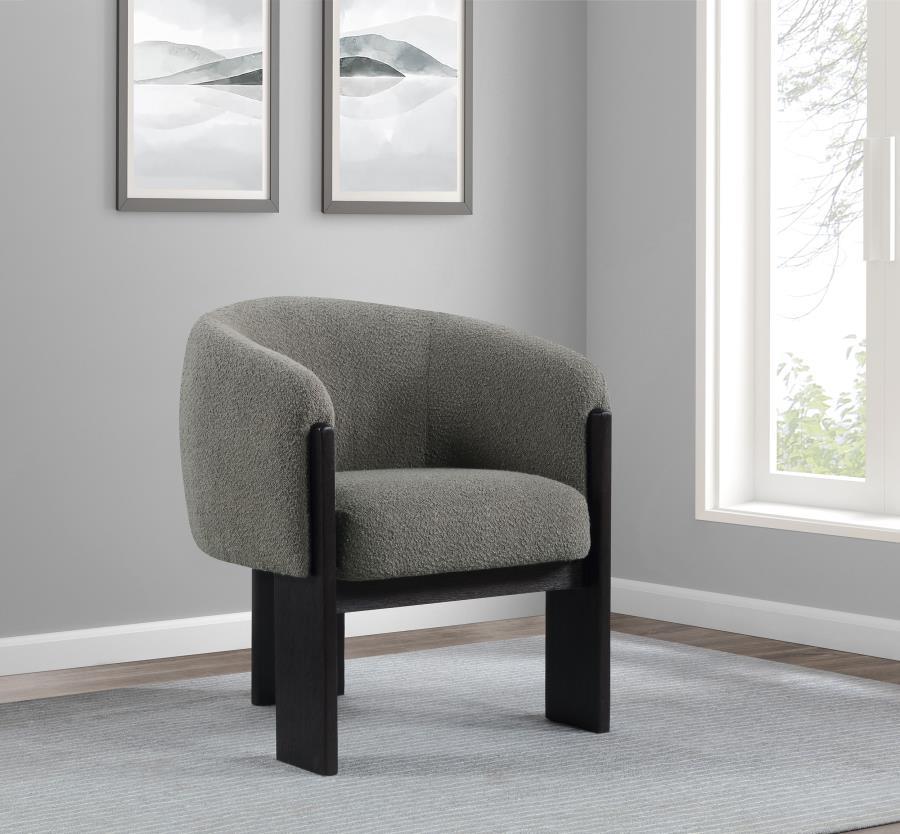 Bring updated style and sophistication to your living room or den with a modern accent armchair. It boasts an inviting rounded silhouette with sloping arms. Three legs in a black finish add a sculptural sensibility. Textured boucle upholstery creates rich