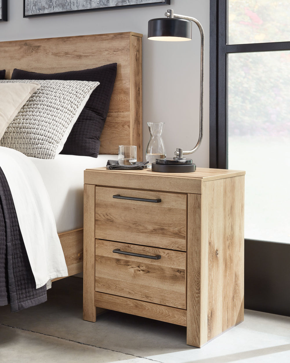 Inspired by natural beauty, refined to perfection. This nightstand brings cozy outdoor vibes to your bedroom with its warm and inviting golden rustic finish. Antiqued gunmetal handles adorn the two drawers on its framed front for an industrial touch, whil