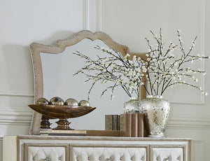  this is an upholstered mirror with exceptional aesthetic details. A row of nailhead trim adds a textured element to the