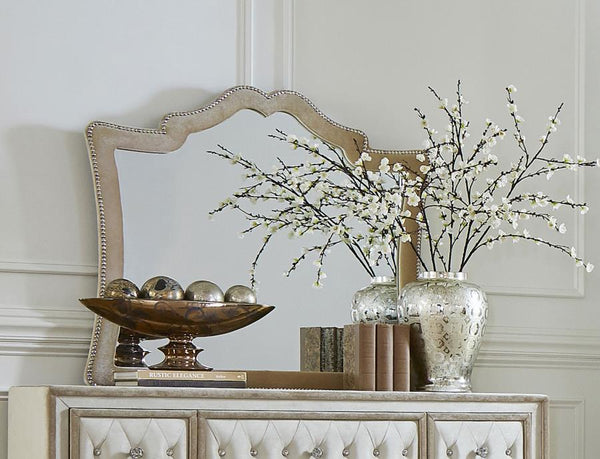  this is an upholstered mirror with exceptional aesthetic details. A row of nailhead trim adds a textured element to the
