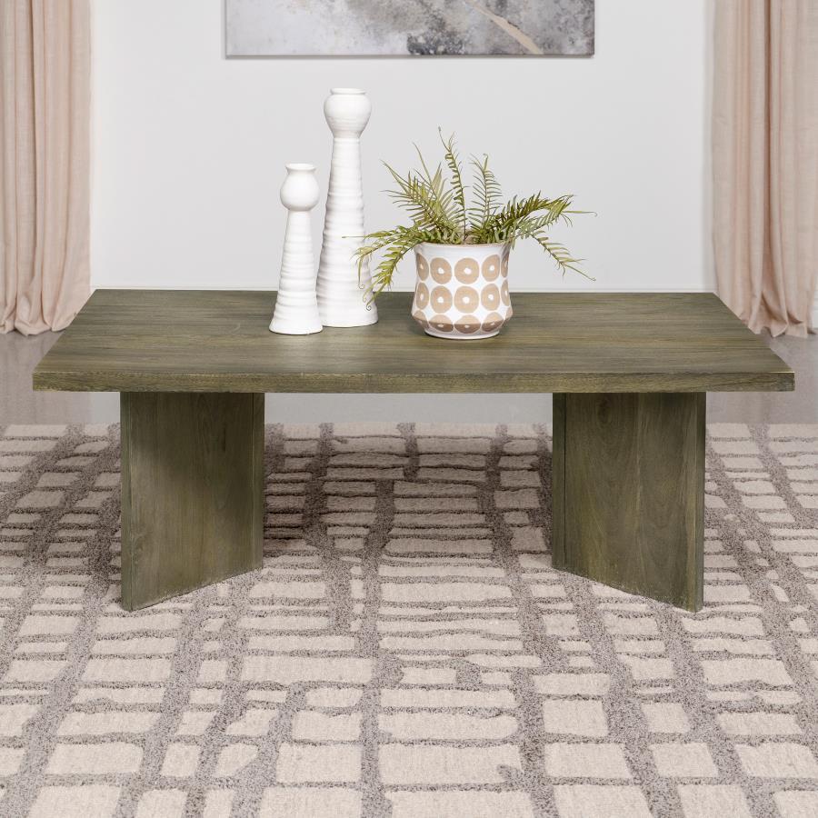 As daylight filters through the windows, it dances upon the surface of a coffee table that exudes a primal elegance. Made from solid mango wood, this rectangular table combines natural charm with timeless durability. Its rich brown finish enhances the woo