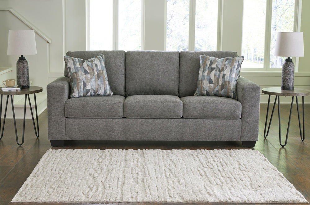 Youâ€™re in for a neat treat with this sofa. Its comfy seats are covered in soft, textural upholstery, and the wide track arms are eager to support your quest for total relaxation. Distressed abstract toss pillows bring a fresh breath of contemporary styl