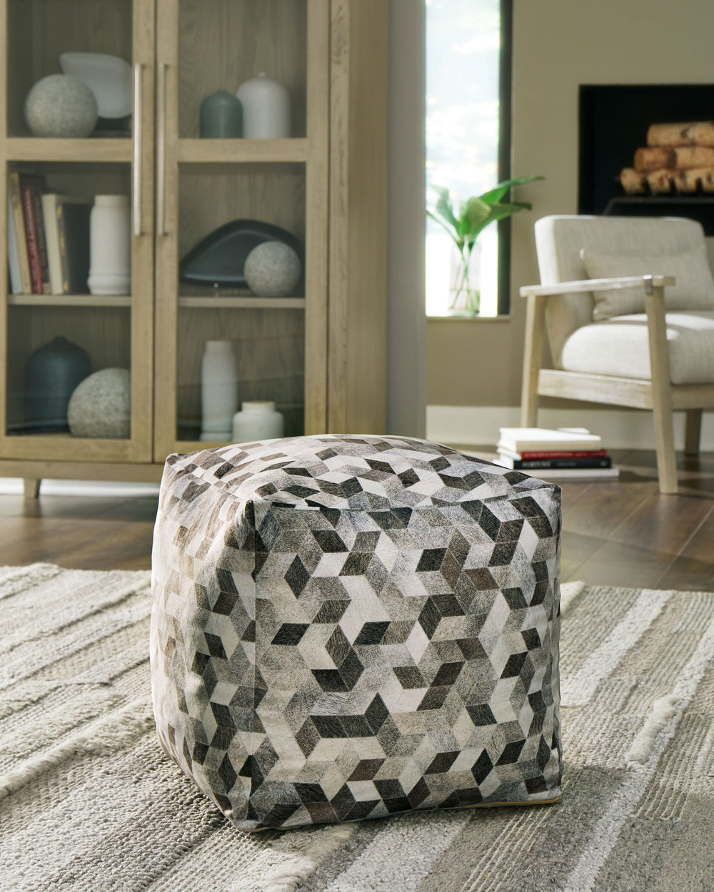 Fall into line with the geometric design of this pouf. Sporting faux hair on hide, this supportive shape in shades of gray and brown invigorates your decor with casually cool flair. Destined to become your favorite footrest, the pouf can also be topped wi