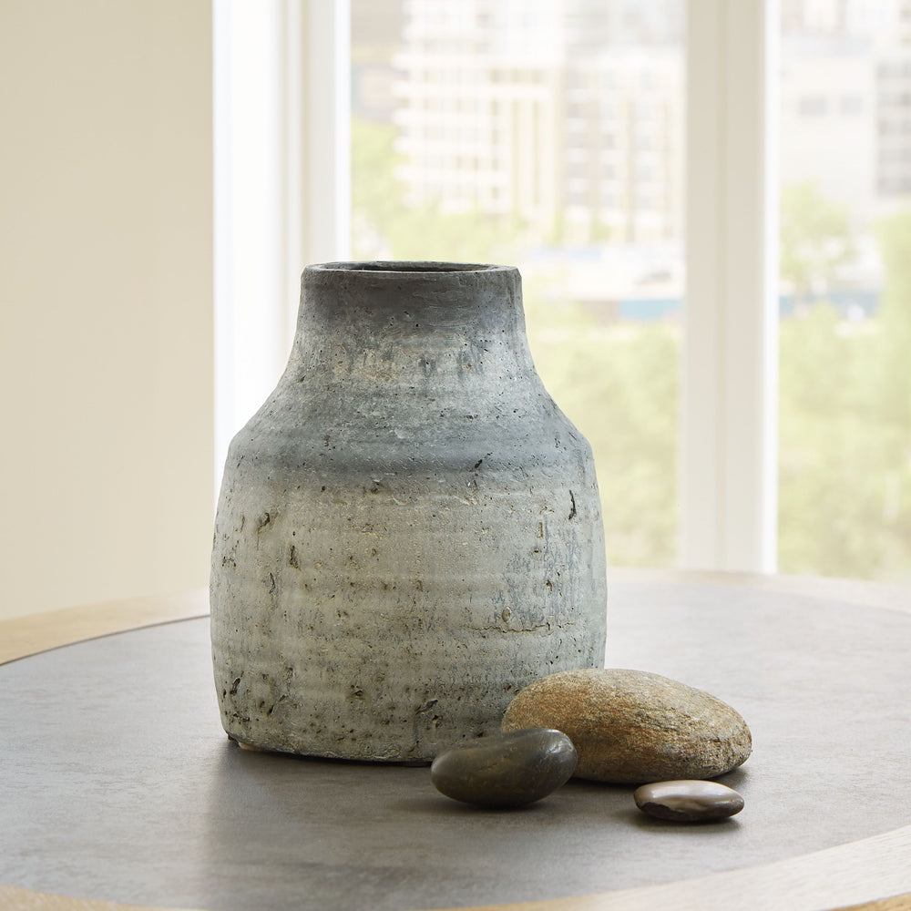 This vase has a weathered aesthetic that adds a culturally sophisticated look to your decor. Display the piece on a table or countertop where its artistry can be appreciated.<br/><br/><b>Product Features</b><ul><li>Made of cement</li><li>Black and gray di