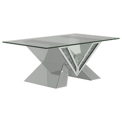 This mirrored coffee table serves as a stunning centerpiece with its bold design. The V-shaped base showcases mirrored panels and sparkling crystal accents for an opulent look. The rectangular, beveled tempered glass top adds elegance and practicality, ma
