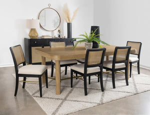 This dining set blends modern craftsmanship with natural textures for a refined yet inviting feel. The dining table features a trestle base with an antique brass-finished metal stretcher bar, adding stability and contrast. Rounded corners soften the recta
