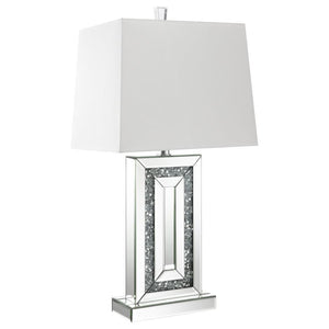 This modern table lamp features a rectangular base framed with beveled mirrored panels and sparkling crushed acrylic crystal inlay. Its geometric design delivers bold symmetry and a touch of glamour, anchored by a crisp white shade that softens the light.