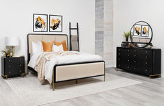 This coastal-inspired bedroom set blends mid-century modern influences with natural textures for a serene retreat. The bed features a cream fabric upholstered headboard and footboard, framed by a wire-brushed wood finish that enhances the beauty of rubber
