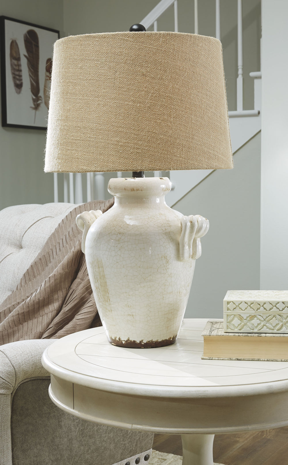 This table lamp illuminates with vintage-inspired style. Antiqued cream glazed ceramic base boasts a crackle effect. Vase shape with the appearance of handles sits beautifully on end table. Perfect for farmhouse and cottage chic spaces.<br><br><b>Addition
