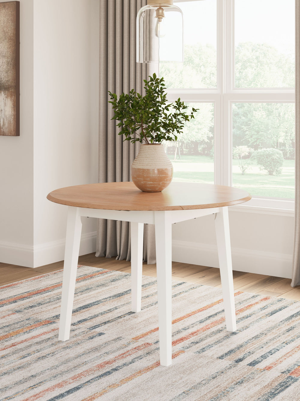 Complement your homeâ€™s simply relaxed sensibility with this drop-leaf dining table. A crisp white hue offers a chic contrast to the natural wood tone, for a neutral look that vibes with a variety of aesthetics. When guests drop by, convert it from a spa