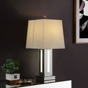 Brighten up your room in sophistication style with this Noralie Table Lamp. Fitting in a variety of design aesthetic, this piece features a classic drum shaped shade. The table lamp showcases a cuboid mirrored base with clear glass and faux stones inlayed