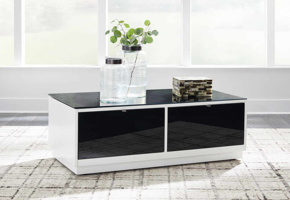 Combining a high-gloss white finish with a black glass tabletop, this coffee table proves opposites really do attract. It-'s the perfect blend of modern style and functionality, with two roomy drawers for storing essentials and a large open display shelf 