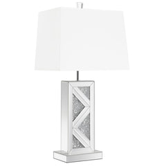 This statement-making table lamp features a rectangular base adorned with mirrored paneling and a bold chevron design inlaid with crushed crystal acrylic. A crisp white shade balances the shimmering base with a clean, structured silhouette. The geometric 