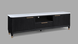 This entertainment console brings modern luxury and sleek sophistication to any living space. Featuring a striking contrast of a black, fluted wood facade with a pristine white faux marble top, this piece embodies refined elegance. Brass-tone accents and 