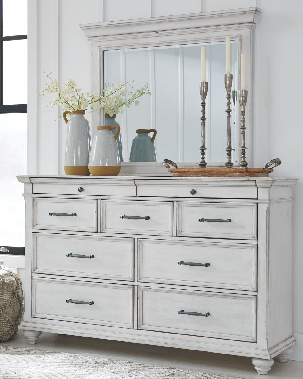 Made with veneers and select hardwood solids in a distressed whitewashed finish. Design features updated traditional styling with generously scaled moulding details. Dresser features 7 full sized drawers with 2 small scaled accessory drawers. Ball bearing