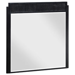 Complete your dresser with a stylish framed mirror. A perfect complement, it features a wooden frame complete with a fluted panel on top that adds rich depth and dimension. The mirror features a black finish with wire brushing that creates textural flair.