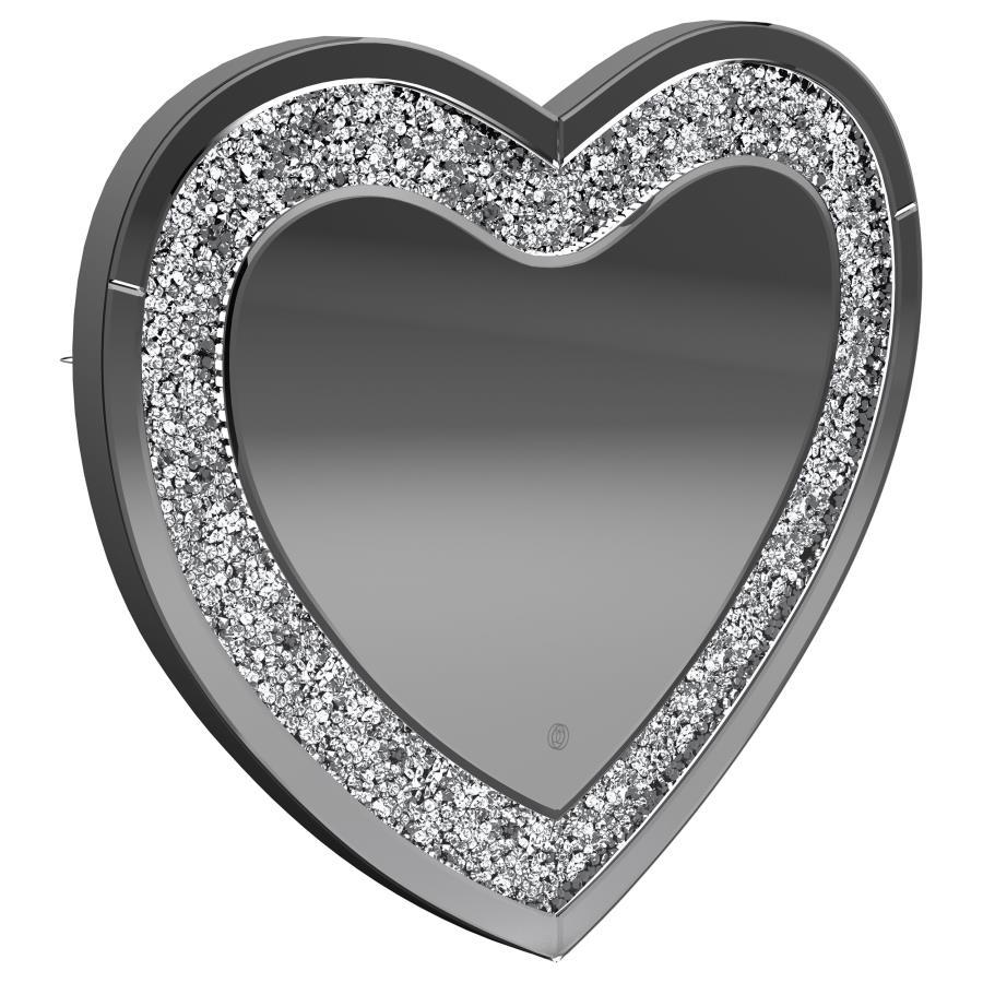 This heart-shaped wall mirror adds sparkle and function to glam-inspired spaces. Framed with mirrored glass and outlined by faceted acrylic crystal inlay, it delivers high-shine appeal. Integrated LED lighting enhances visibility for makeup, grooming, or 