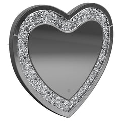 This heart-shaped wall mirror adds sparkle and function to glam-inspired spaces. Framed with mirrored glass and outlined by faceted acrylic crystal inlay, it delivers high-shine appeal. Integrated LED lighting enhances visibility for makeup, grooming, or 