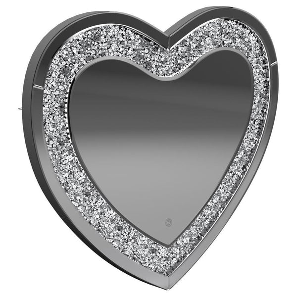 This heart-shaped wall mirror adds sparkle and function to glam-inspired spaces. Framed with mirrored glass and outlined by faceted acrylic crystal inlay, it delivers high-shine appeal. Integrated LED lighting enhances visibility for makeup, grooming, or 