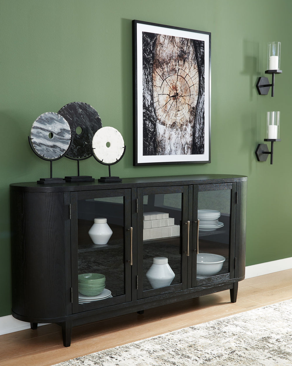 Inspired by art deco design, this dining server makes a lasting impression in a simply stunning way. Its magnificent rounded silhouette is enhanced with a rich layered black finish on the textured wood grain surface. Complete with glass cabinet doors, int
