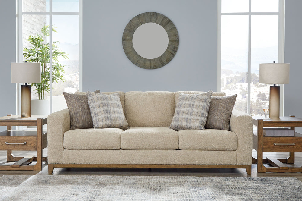 Serene style with a modern sensibility. Delight in the cozy, versatile embrace of this sofa. It takes an on-trend approach to irresistible texture and natural beauty, showcasing soft upholstery accented with a transitional wood trim. As refined as it is l