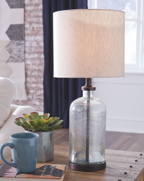  this seeded glass lamp illuminates a cool vibe in any space. The bronze-tone finish gives this piece a vintage slant while the drum shade provides the clean