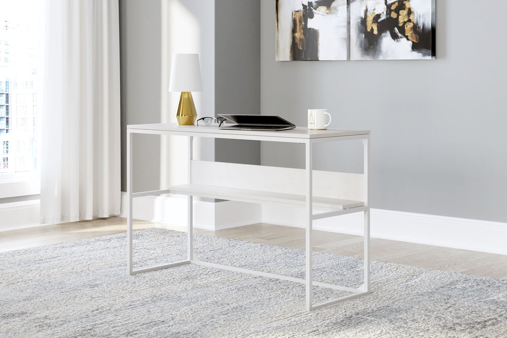 Bring your vision of a modern home workspace to life with this sleekly designed home office desk. Its linear construction and white finish keep things minimal. A small shelf along the back rounds out the versatile, striking desk.<br><br><b>Additional Dime