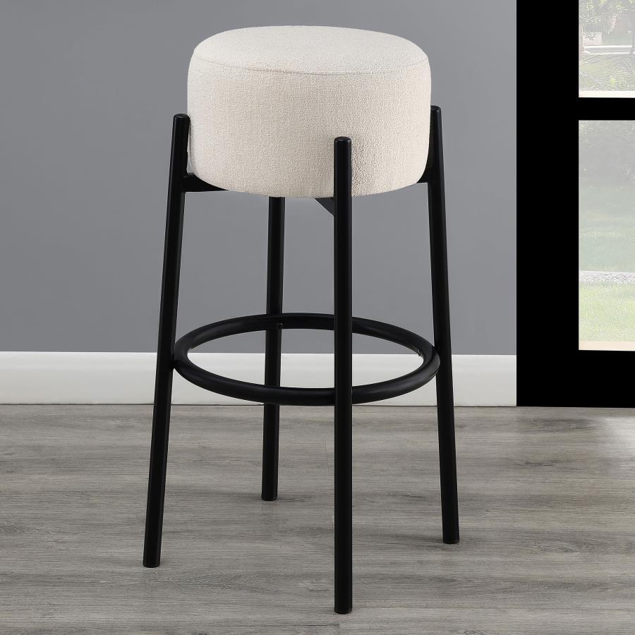 Casual with sleek lines, slide this pair of contemporary stools up to a bar or kitchen breakfast area. Designed with a thick pouf-like cushion wrapped in a white upholstery, this stool lends an elegant playful charm to any space. The pouf-inspired seat re
