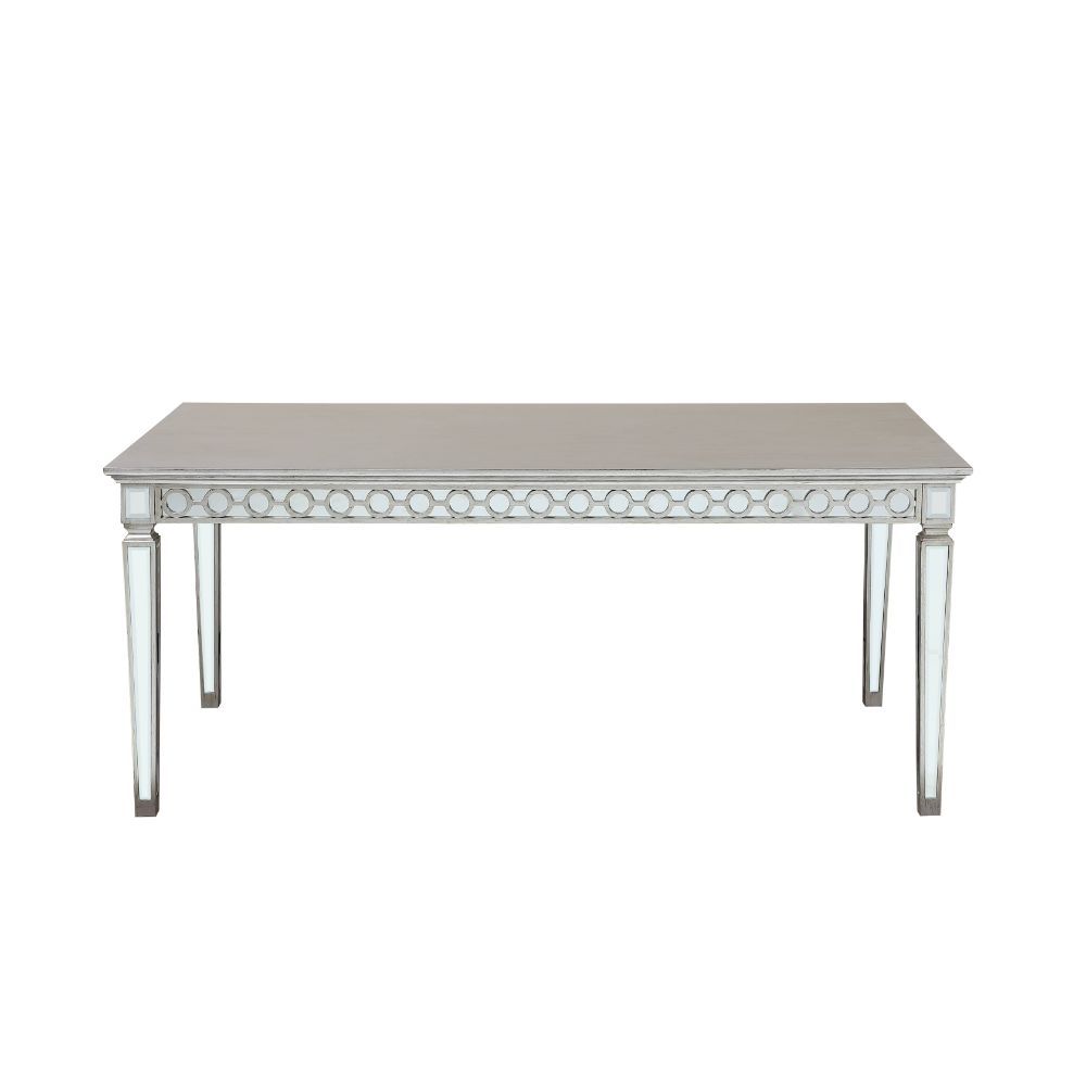 Let the Varian dining collection reflect your brilliant style! This chic set features a rectangular table accented with a beveled mirror trim in a geometric design. The matching chairs are upholstered in a lustrous blue fabric and supported by elegantly t
