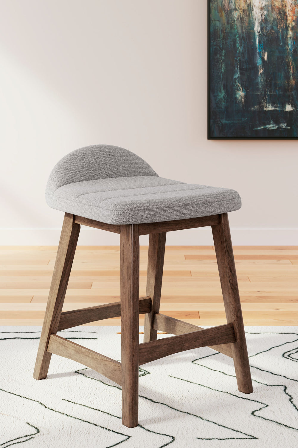 A refreshed take on retro aesthetics. This upholstered bar stool adds an air of playful simplicity to your dining space, capturing the architectural language of mid-century stylings. The seat invites the eye with a soft-edged silhouette and light gray cus