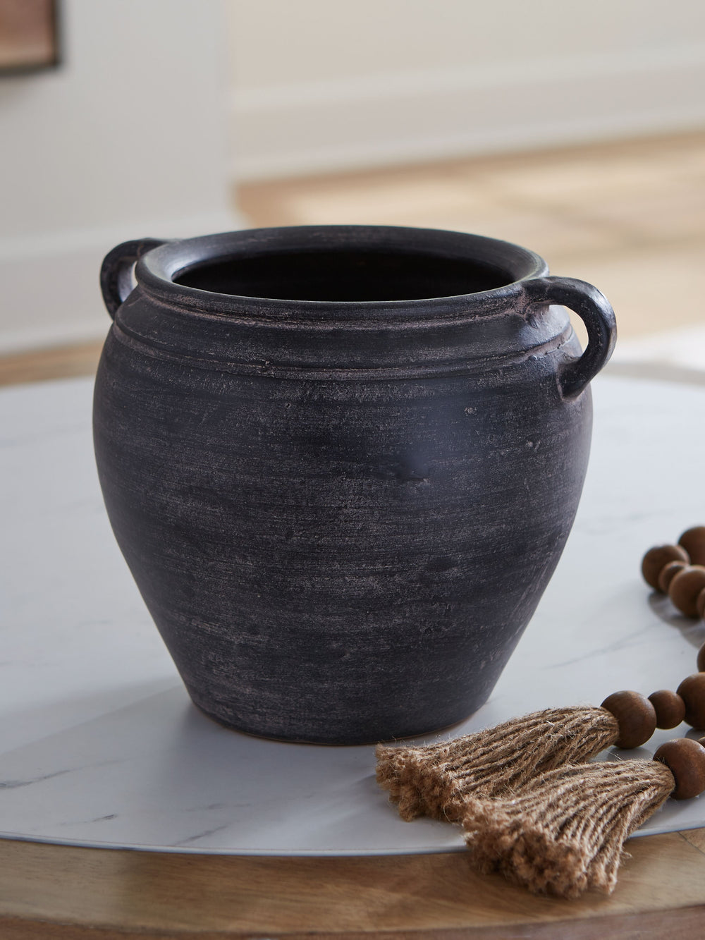Celebrate the artisanal character of ceramics with this vase. Its distressed black finish has a time-worn, weathered appeal, offering the look of the past with a modern feel. The vase-'s neutral tone makes it a go-to for all seasons, allowing you to stage
