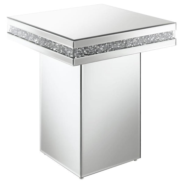 Showcase sculptures and decor on this stunning, modern glam accent table. A square table sits on a tall square pedestal for an edgy, bold expression. Smooth mirror trim and surfaces cover every edge, creating a sleek flair. Glittering acrylic crystals lin