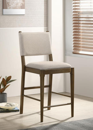  making it a perfect addition to casual dining spaces. Upholstered in soft light tan fabric