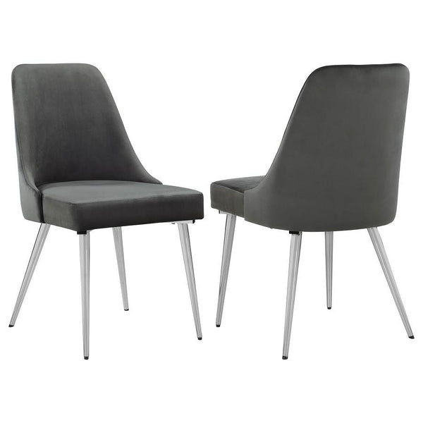 This modern dining chair blends sleek design with luxurious comfort, making it a perfect addition to any dining space. Upholstered in soft grey velvet, the plush padded seat and curved backrest provide a supportive and inviting feel. Tapered metal legs in