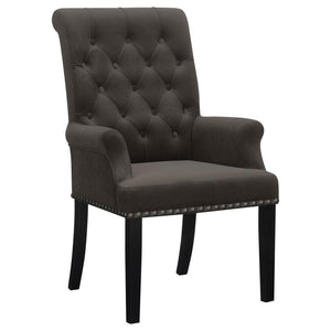Designed for both luxury and support, this arm chair brings an elegant presence to any dining space. Its button-tufted high back and rolled top lend a timeless aesthetic, while the addition of padded armrests enhances comfort. Hand-applied nailhead trim o