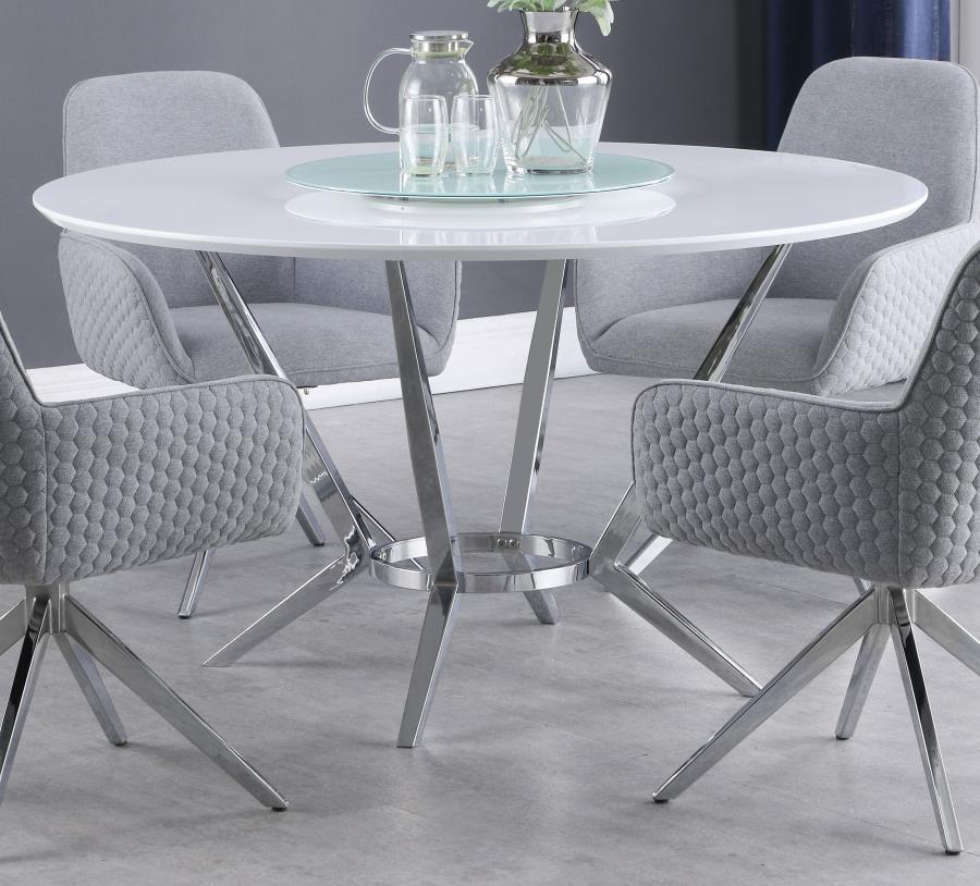 Elegant and ultra-modern, this round dining table pairs a high gloss white top with a tempered glass lazy Susan for added function. Its metal base features boomerang-style legs finished in electroplated chrome, delivering sculptural appeal and stability. 