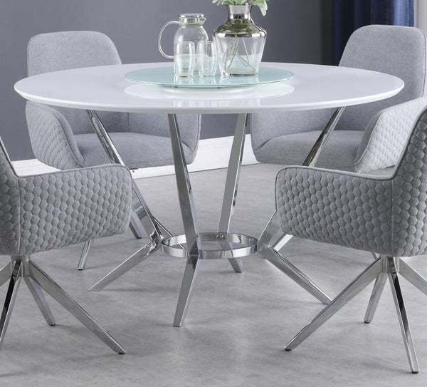  this round dining table pairs a high gloss white top with a tempered glass lazy Susan for added function. Its metal base features boomerang-style legs finished in electroplated chrome