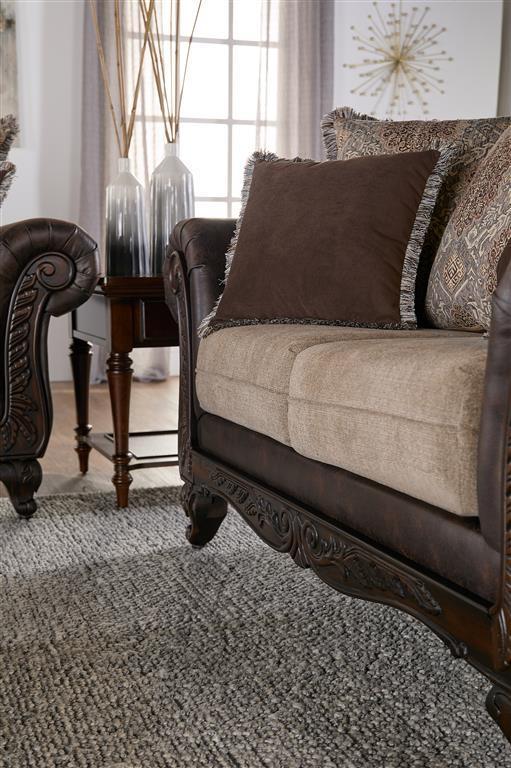 Bring robust design and a veritable tapestry of color and pattern to your living room with this traditional loveseat. It stands out with dramatic rolled arms augmented with smooth dark brown faux leather that adds depth and contrast to coordinating fabric