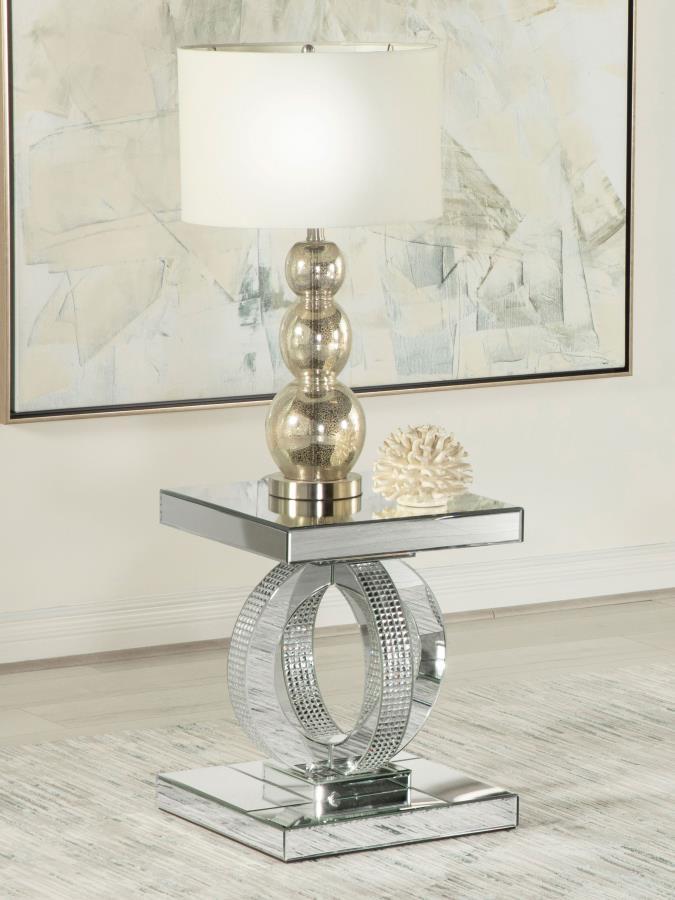 This glamorous mirrored end table brings Hollywood Regency refinement to your space. Its base features interconnected dual rings adorned with dazzling acrylic crystals, while every other surface is wrapped in sleek mirrored panels. Softly beveled edges ad
