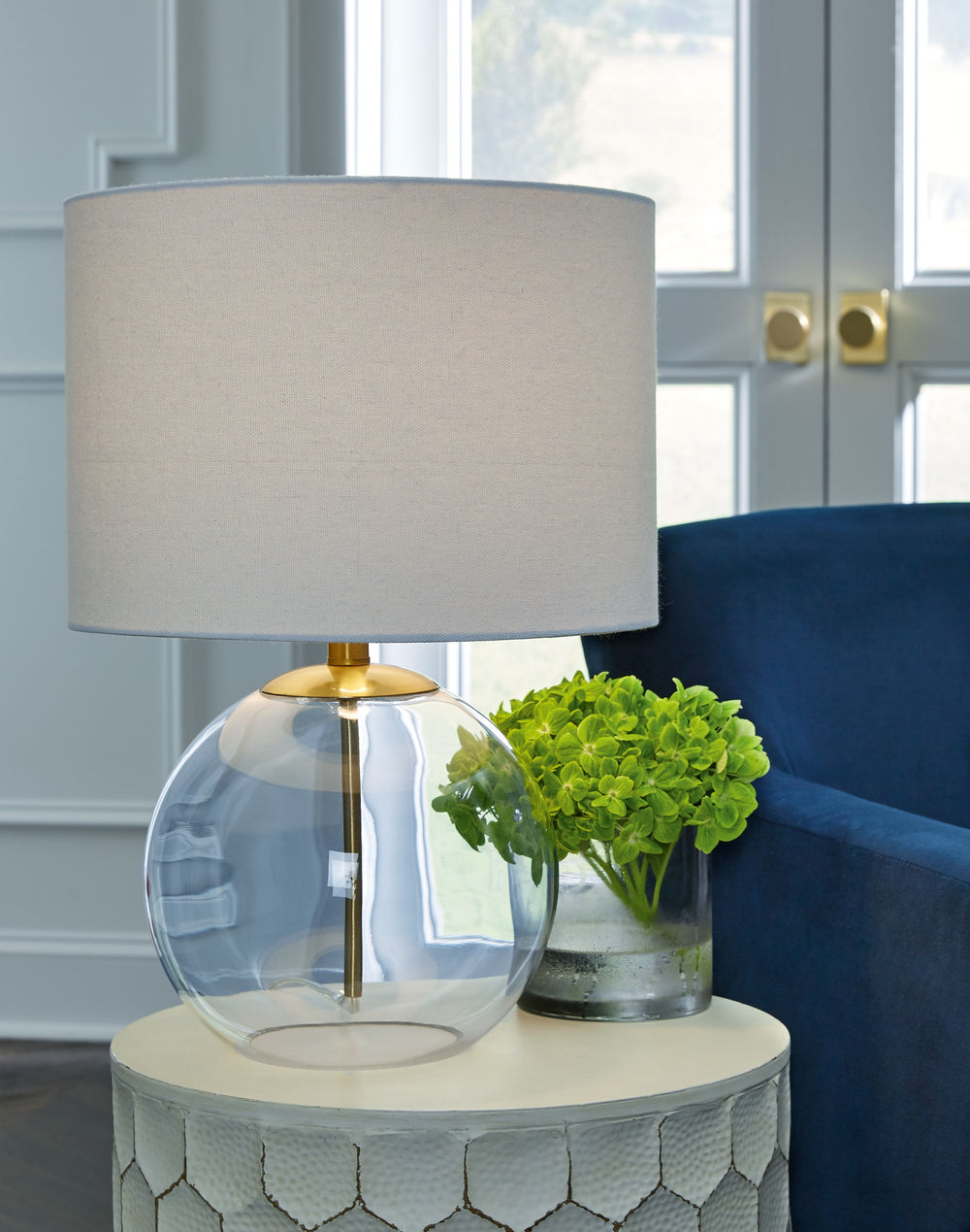 Featuring a round, clear glass base, this table lamp has a clean sculptural appeal that-'s easy to implement into a variety of decor styles. Its sheer simplicity exudes a clean, fresh aesthetic, adding low-key glamour to your bedroom or living room.<br><b