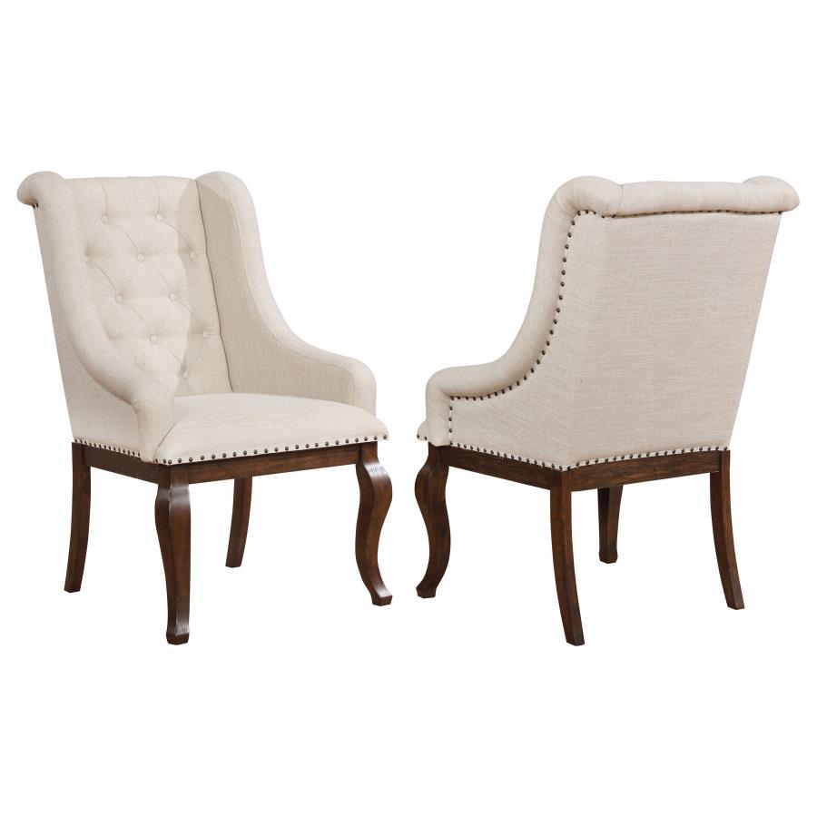 Go full-scale indulgent with this inviting dining arm chair. Beautifully upholstered in a neutral tone, the chair features sloping arms that draw the eye and offer superb comfort and support. Its button tufted back lends classic style. Nailhead trim creat