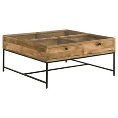 Bring farmhouse charm to your living room with this shadowbox coffee table. A tempered glass top offers a clear view of treasures stored in four compartments, accessed by drop-front doors with chain suspension for a unique touch. Crafted from solid mango 