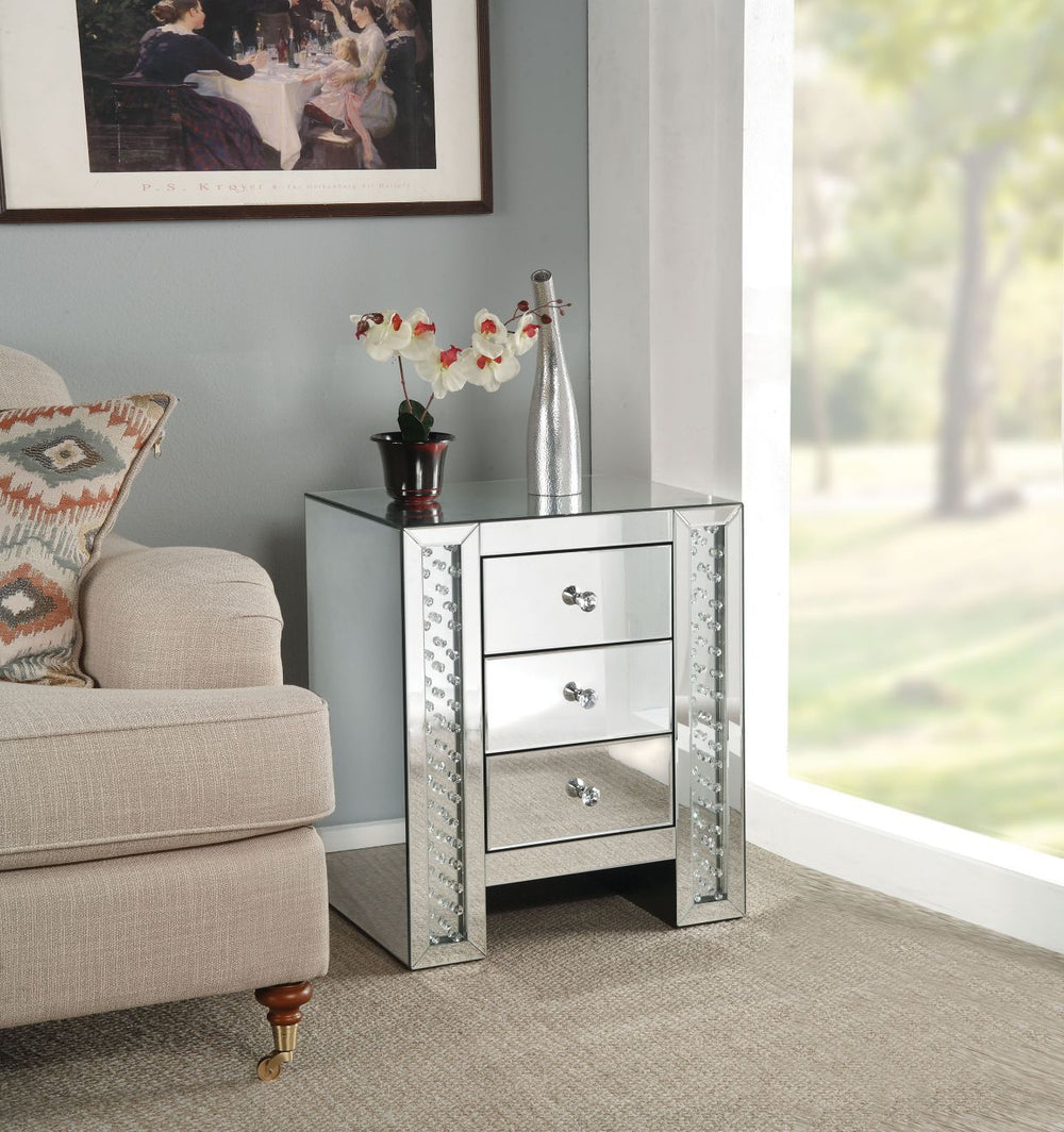 The Nysa mirrored occasional table demonstrates sophisticated, graceful and elegant, style with unique design. This table features three storage drawers decorative drawer pull knobs. While elegantly reflecting its surroundings, combines glamour with moder