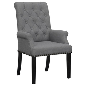 Designed for both luxury and support, this arm chair brings an elegant presence to any dining space. Its button-tufted high back and rolled top lend a timeless aesthetic, while the addition of padded armrests enhances comfort. Hand-applied nailhead trim o