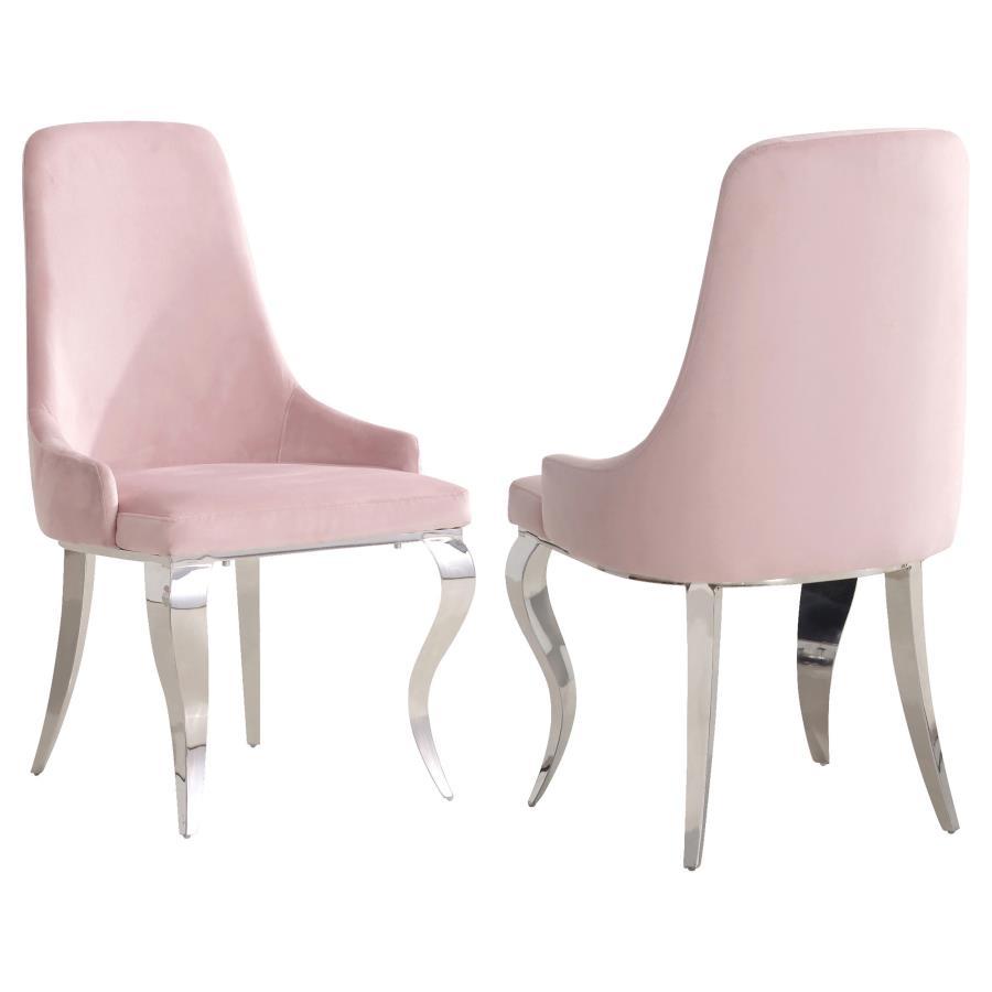 Elevate your dining space with the luxurious charm of this upholstered side chair. Wrapped in soft light pink velvet fabric, it features a graceful slipper-style silhouette with a high back and demi arms for added elegance. The sculptural cabriole legs, c